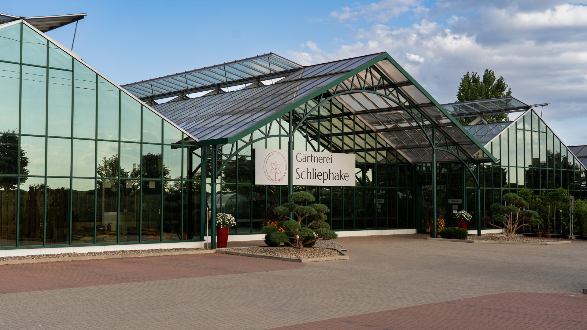 Glasgewächshaus mit Eingangsschild